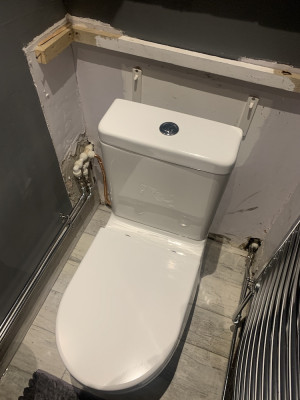 New toilet in front of outlet as installed by plumber