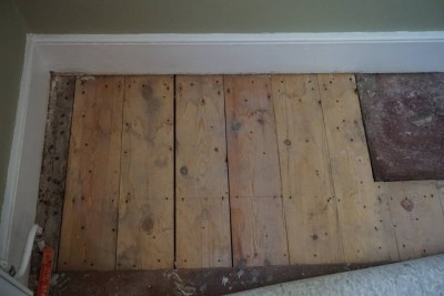 Left side, newer boards, evidence of damp staining coming in from wall. not currently wet.