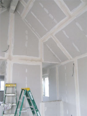 Drylining or plaster boarding walls