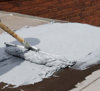 Using a squeegee to spread roof repair coating