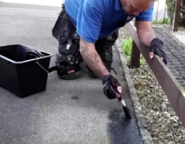 Cutting in tarmac restorer along edging stones before rolling