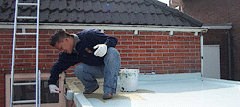 Applying resin to roof surface in preparation for laying roofing material