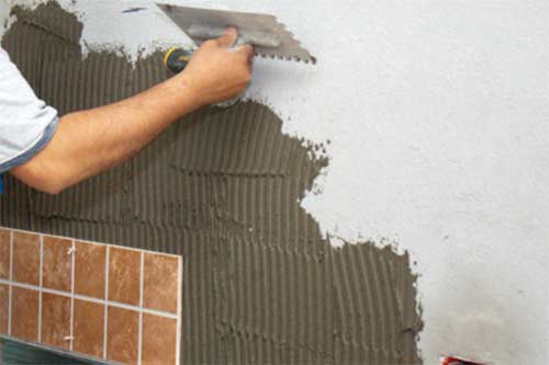 Applying adhesive to wall