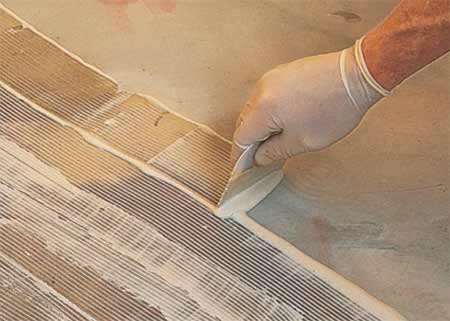 Applying floor tile adhesive