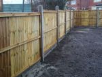 Panel fence constructed using concrete fence posts