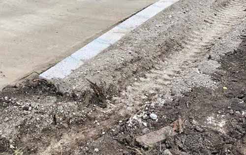 Edging stones laid at side of driveway to contain gravel and stop it spreading