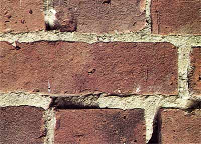 Old brickwork with broken and missing mortar in joints