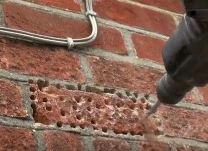 Brick drilled full of holes ready for breaking up