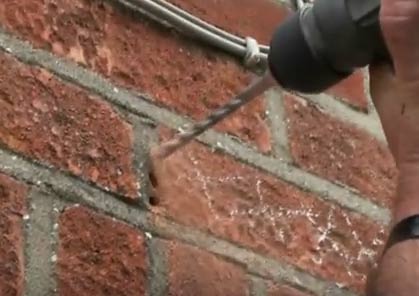 Drilling out old mortar to remove brick