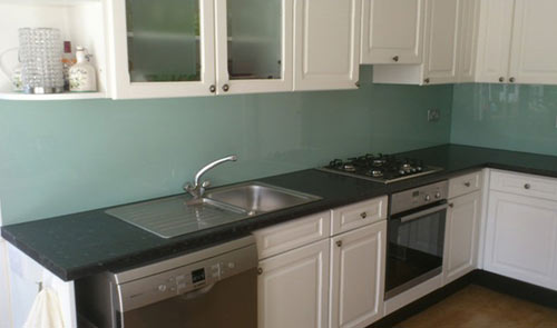 Acrylic splashback between worktop and wall units