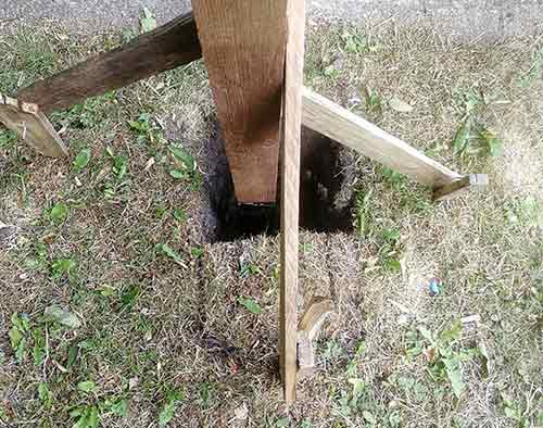 Fence post braced and leveled upright while cement/Postcrete cures