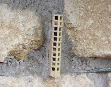 Plastic weephole vent inserted into brickwork joint