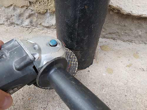 Cutting old cast iron soil pipe using a grinder 