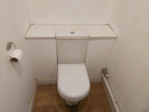 Toilet and cistern fixed in place and secured to boxing framework