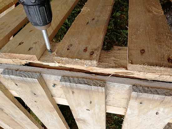 Hold chicken coop roof together roughly with scrap timber