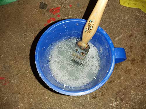 Paint brush dipped in hot soapy water