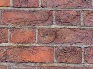 Brick wall showing faces have been blown off the bricks