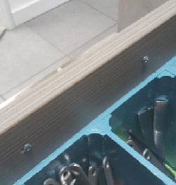 Inside of kitchen drawer showing screws used to fix handle