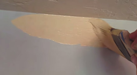 Cutting into joint between the top of the wall and the ceiling