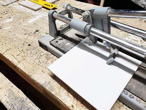 The snapping foot of the tile cutter can be used to snap tile along cut line