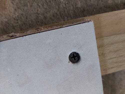 Screw inserted just below surface of plasterboard
