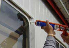 Using a silicone gun to waterproof windows and doors