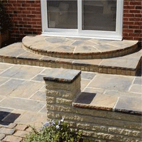 Patio constructed using quarry slabs featuring a stepped area and wall