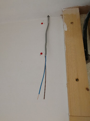 Electrical supply cable run up through hole in ceiling