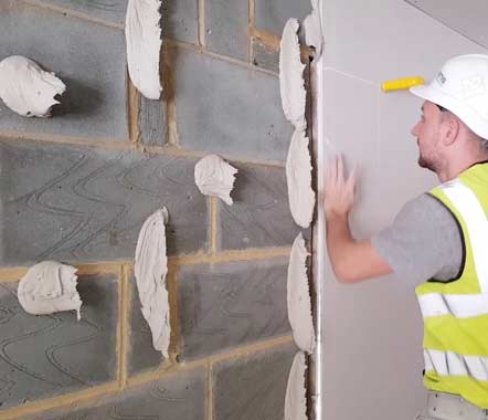 Fixing plasterboard to a wall using dot and dab