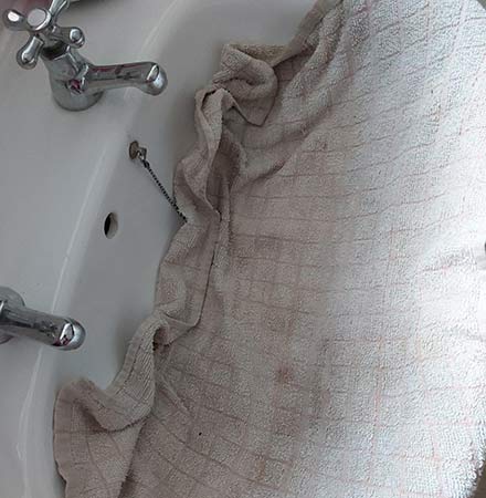 Lay a cloth or tea towel over the sink to protect it
