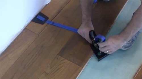 Use floor tensioners to close floor plank gaps