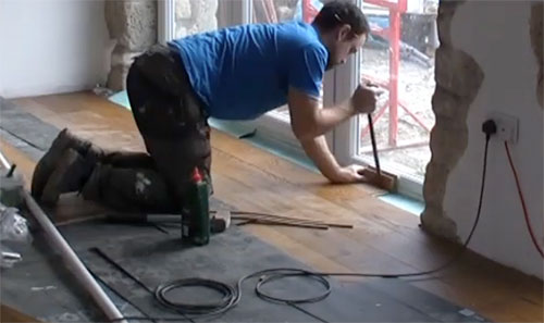 Using a pry bar to close a joint in a laminate floor