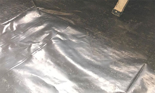 Screeded floor covered with polythene sheet to allow it to cure