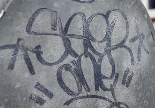 Graffiti to be cleaned off of metal surface