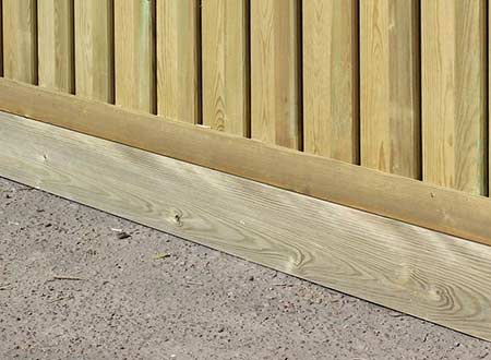 Timber gravel board fitted in place on a fence