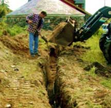 Trench containing ground source heating pipes being filled in