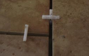 Tile spacers inserted into floor tiles leaving 5mm gap