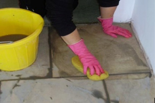 Using a sponge to wash off excess tile grout