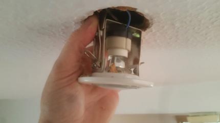 Sliding the downlight into the hole in the ceiling