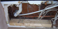 shower waste trap and pipework exposed through ceiling below