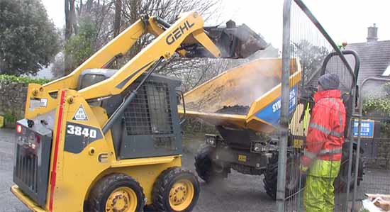 Loading bitmac from lorry into dumper using bobcat