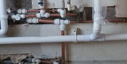 Waste pipe clipped to wall using pipe clips