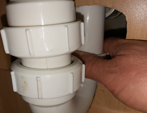 Unscrew existing waste trap from under sink
