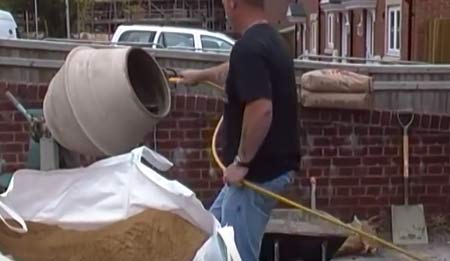 Using a hose to add water to cement mixer