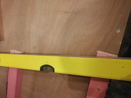 Using a spirit level to mark the mitre angle for the roof