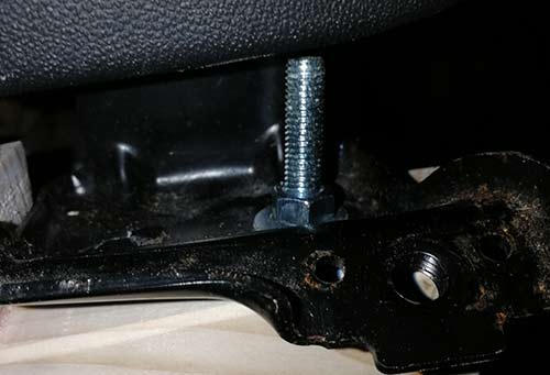 Nut screwed onto bolt and tightened down, fixing car seat to mounting