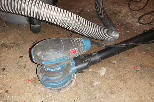 Vacuum attached to sander to reduce volumes of dust