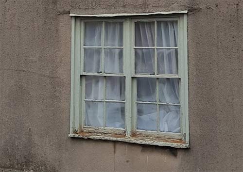 Sash window in need of repair and painting