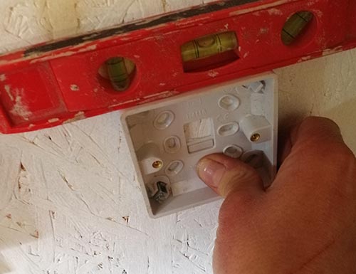 Levelling plastic back box using a spirit level