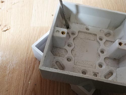Tap out thin plastic coverings from screw fixing points